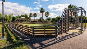 A playground with a basketball court, a climbing structure, and a solar-powered light post. - Charming villa with garden for 6 pers (Homps)