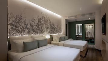 A hotel room with two beds, a large wall mural, a walk-in closet, and a TV.