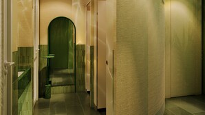 Un interior moderno con una pared curva, una puerta verde y un suelo de baldosas.