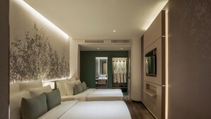Habitación de hotel con dos camas, una obra de arte grande en la pared, un espejo, un armario y un televisor.