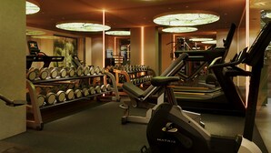 Un gimnasio con cintas de correr, mancuernas y un amplio tragaluz circular.