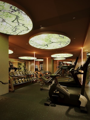 A gym with treadmills, dumbbells, and a large circular skylight. - KiN Hotel Central Park (Ho Chi Minh City)