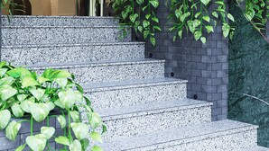 A hotel entrance with a modern design, featuring a staircase leading up to a reception area. - KiN Hotel Central Park (Ho Chi Minh City)