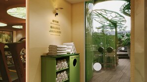Un pasillo con un perchero verde, un cartel en la pared y una puerta de vidrio que da a un área exterior.