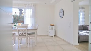 A bright, modern living space with a dining area, a small kitchen, and a bedroom. - Top modern vacation apartment 90 m² in a central location in Grömitz. (Grömitz)