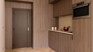 A modern kitchen with wooden cabinetry, a built-in oven, and a small countertop with kitchen items. - Harmony Collection I 2BR Suite 4P AC Opera Grevin (Paris)