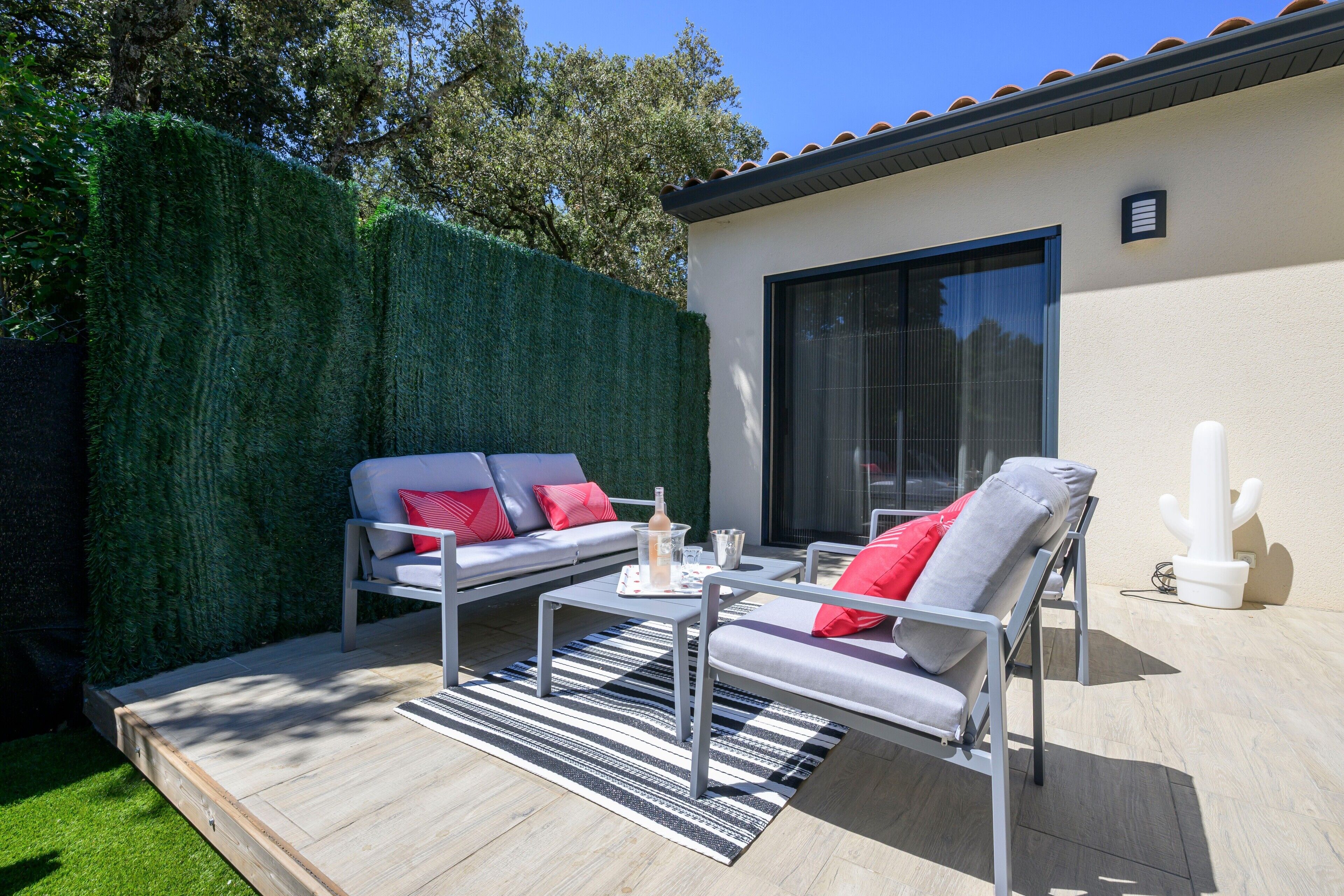 Une terrasse extérieure avec un canapé, des fauteuils et une table.