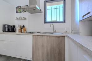 Une cuisine moderne équipée d’une cuisinière intégrée, d’un évier et d’une fenêtre donnant sur un beau paysage.