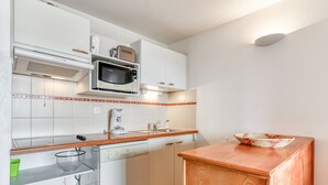 A modern kitchen with white cabinets, a microwave, a coffee maker, and a dishwasher. - apartment with sea view, sleeps 6, balcony (Valras-Plage)