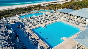Un resort con varias piscinas, tumbonas y vistas a la playa.