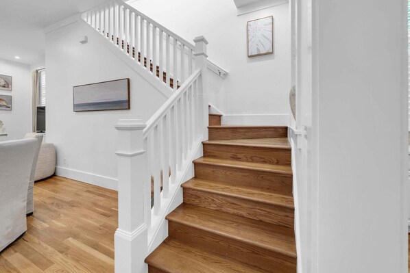 A staircase with white railings and wooden steps leading to an upper floor. - 🦩Book Me Baby! Beach Cruiser Cottage in WaterColor Golf Cart & Bikes🦩 (Santa Rosa Beach)