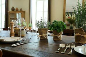 A dining table set with plates, cutlery, and glassware, with small potted plants and a salt shaker. - Le Parc - Hôtel & Spa (Allevard)