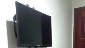 A television mounted on a wall with a power outlet below it. - Capital O 91275 Pr Motel (Changlun)