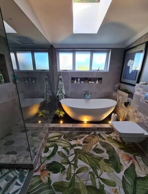 Tina de hidromasaje, toallas, papel de baño