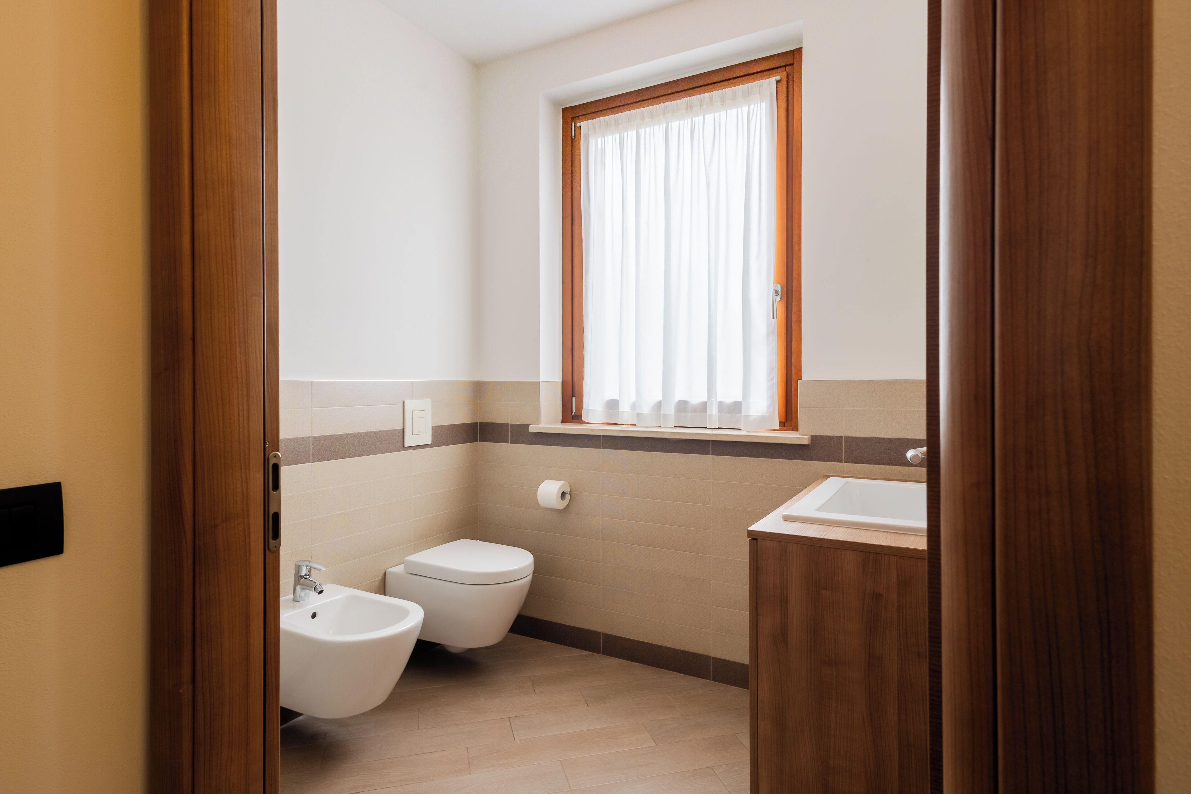 A bathroom with a bidet, toilet, and sink.