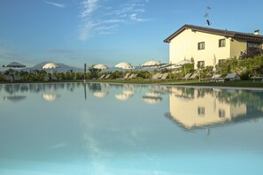 Een seizoensgebonden buitenzwembad, parasols voor strand/zwembad