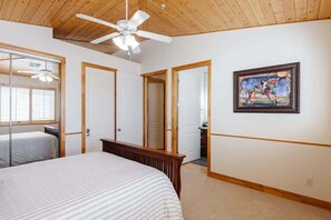 A bedroom with a large bed, a ceiling fan, and a painting on the wall. - Las Palmas Resort #808 | All-Inclusive Amenities (Saint George)
