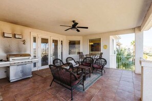 A covered patio with a grill, dining area, and chairs. - Las Palmas Resort #808 | All-Inclusive Amenities (Saint George)