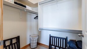 A small, enclosed room with a white door, a metal radiator, a white laundry basket, and a black chair. - Las Palmas Resort #808 | All-Inclusive Amenities (Saint George)