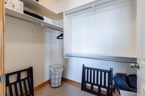 A small, enclosed room with a white door, a metal radiator, a white laundry basket, and a black chair. - Las Palmas Resort #808 | All-Inclusive Amenities (Saint George)