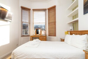 Ein Hotelzimmer mit einem Bett, einem Schreibtisch mit Lampe und einer Heizung.