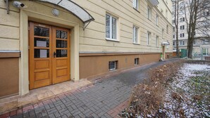 En byggnad med en stor trädörr, ett välvt markis och en stenlagd trottoar.