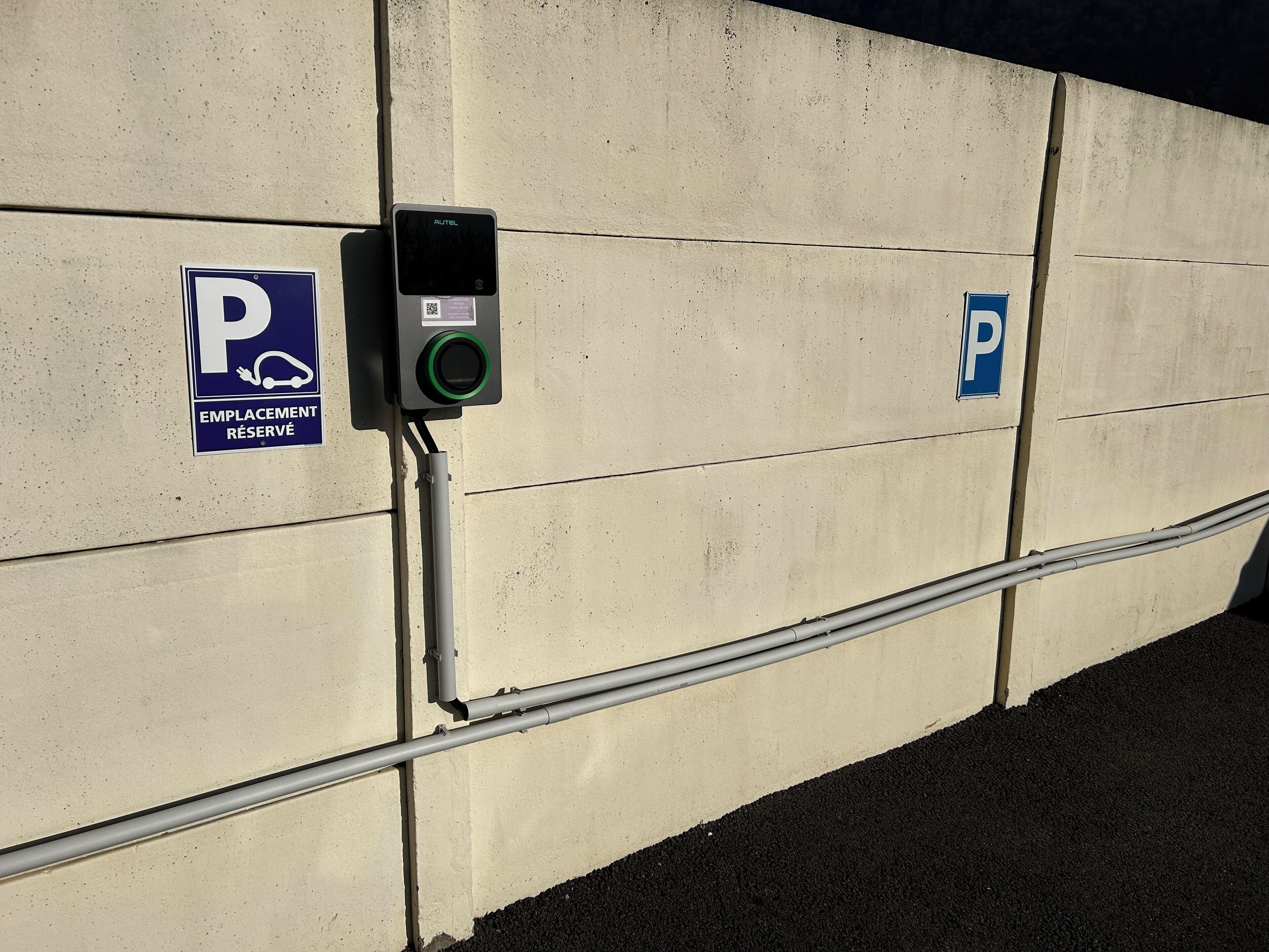 Un espace de stationnement avec deux panneaux indiquant les places disponibles : l’un pour les places réservées et l’autre pour les places de stationnement général.