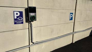 Un espace de stationnement avec deux panneaux indiquant les places disponibles : l’un pour les places réservées et l’autre pour les places de stationnement général.