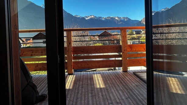 A wooden deck with a view of snow-capped mountains.