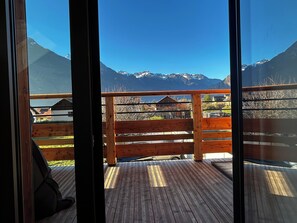 Terraza de madera con vistas a montañas nevadas.