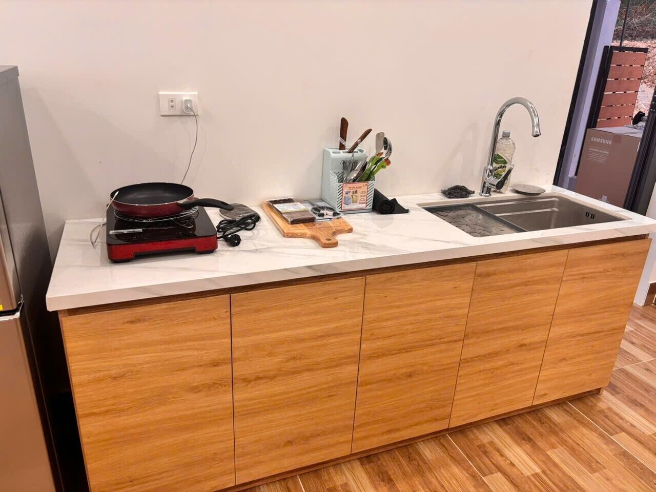 Una cocina moderna con un lavaplatos integrado, armarios de madera y una encimera.