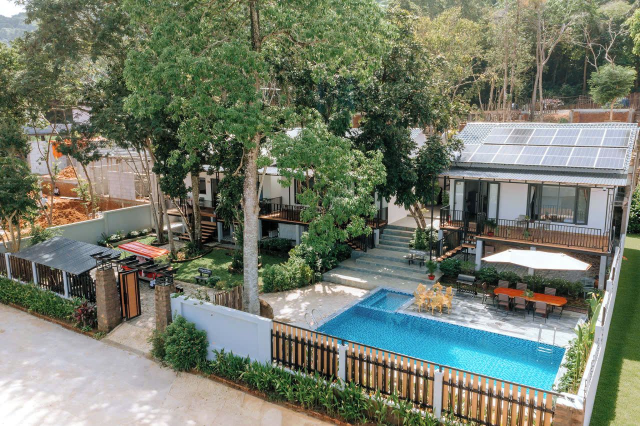 Una propiedad residencial con piscina, paneles solares y un patio cubierto.