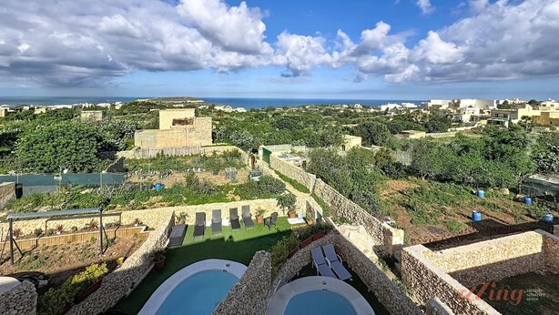 A resort with a pool area, lounge chairs, and a view of the sea and surrounding buildings. - Peaceful Home with Private Pool and Rooftop Jacuzzi (Ix-Xagħra)