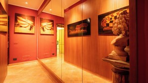 Un pasillo con paneles de madera, suelo de baldosas y obras de arte en las paredes.