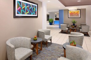A lobby with grey upholstered chairs, a patterned rug, and two framed abstract artworks on the walls. - Near Univ of Texas Austin + Pool. Bar. Breakfast. (Austin)
