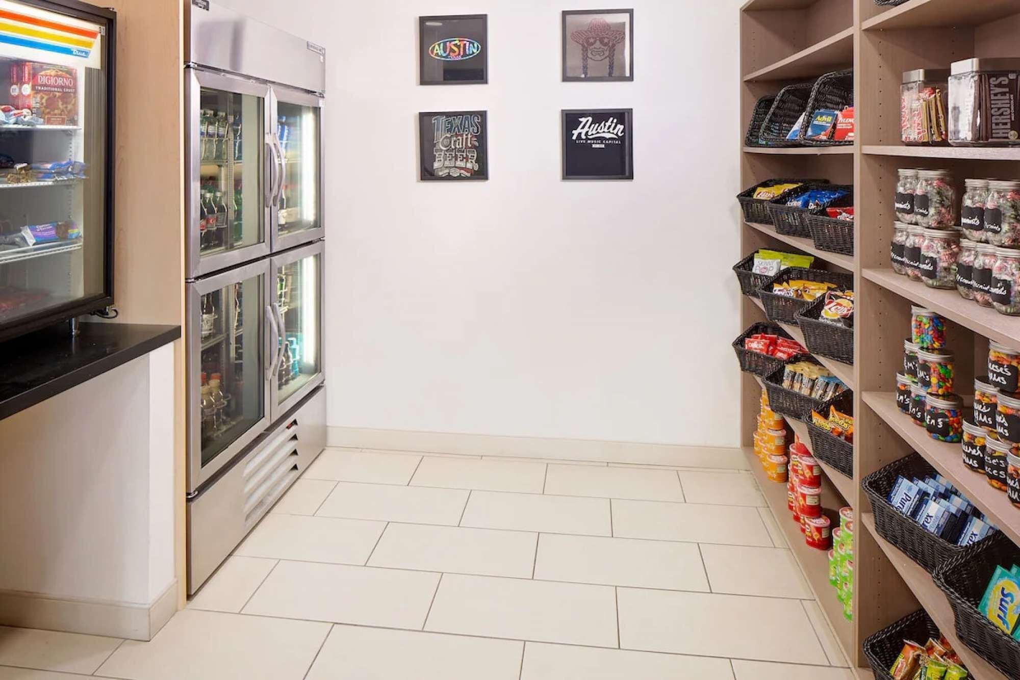 A snack bar with refrigerated display cases, a vending machine, and shelves stocked with various snacks and beverages.