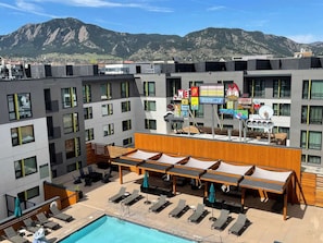 A hotel rooftop with a swimming pool, lounge chairs, and a view of mountains. - Close to CU Boulder + Free Breakfast. Pool. Gym. (Boulder)