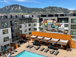 A hotel rooftop with a swimming pool, lounge chairs, and a view of mountains. - Near CU Boulder + Free Breakfast. Pool. Fitness. (Boulder)