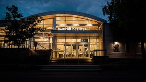 A building with a sign reading "DAIRYARTS CENTER" at night.