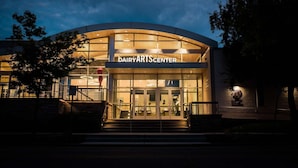 A building with a sign reading "DAIRYARTS CENTER" at night. - CU Game Days | Restaurant + Mobility Access Room (Boulder)
