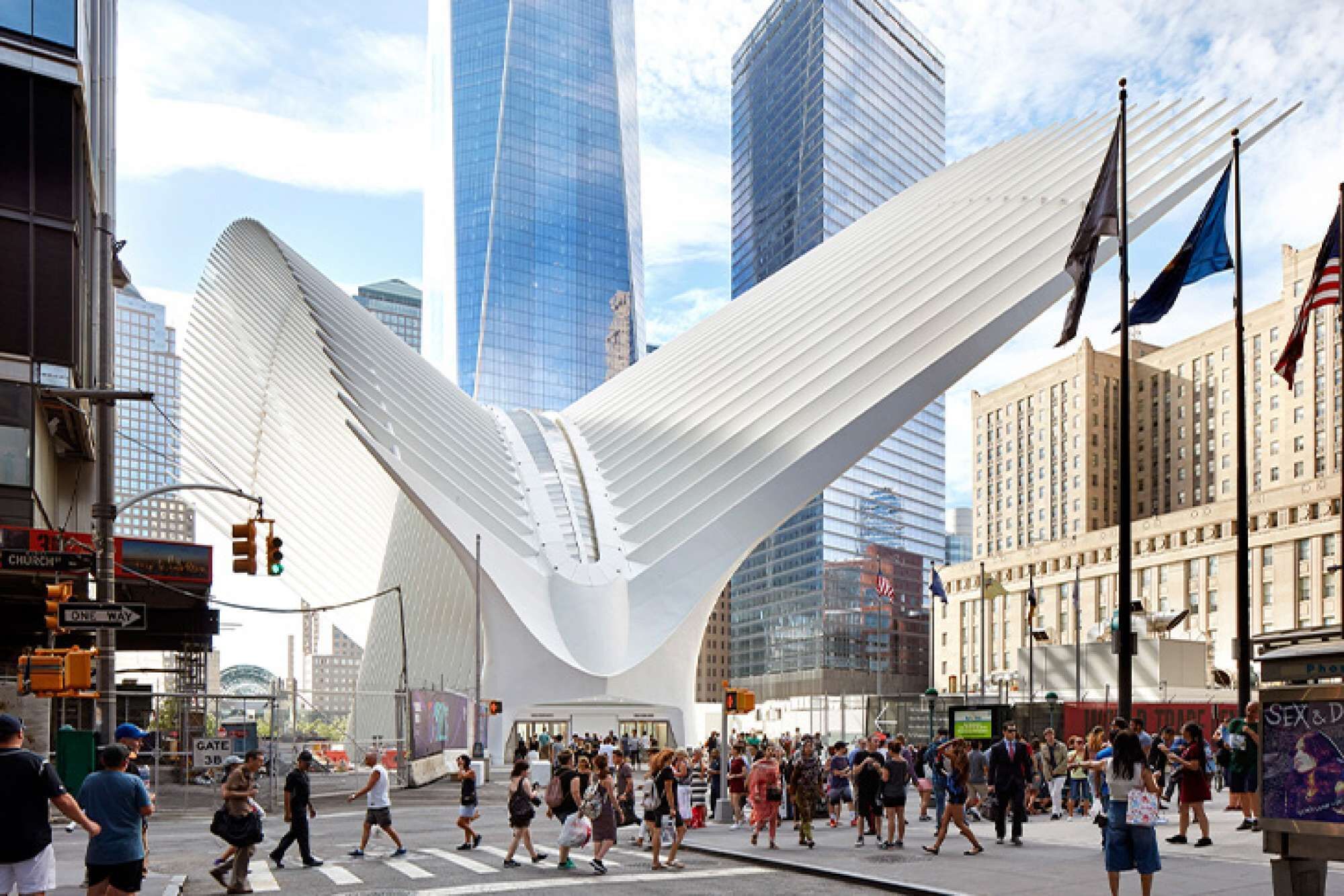 A modern urban plaza with a distinctive white structure, surrounded by high-rise buildings and busy pedestrian traffic.
