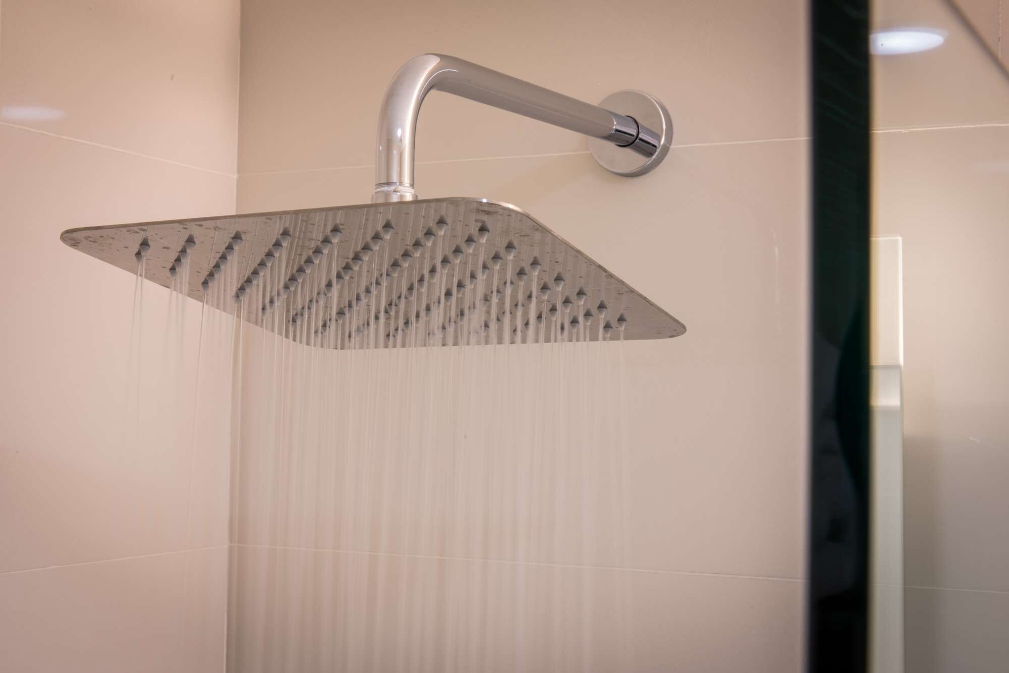A modern shower with a square design and multiple water jets.