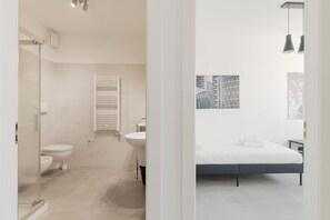 A modern bathroom with a glass shower enclosure, a toilet, and a sink. - GuestHost - Modern 90 sqm apartment, accommodating up to 5 guests, located on the eighth floor of a building with an elevator (NOT suitable for guests with disabilities).The property is set in a residential area of the Greco Pirelli district in Milan, a  (Milan)