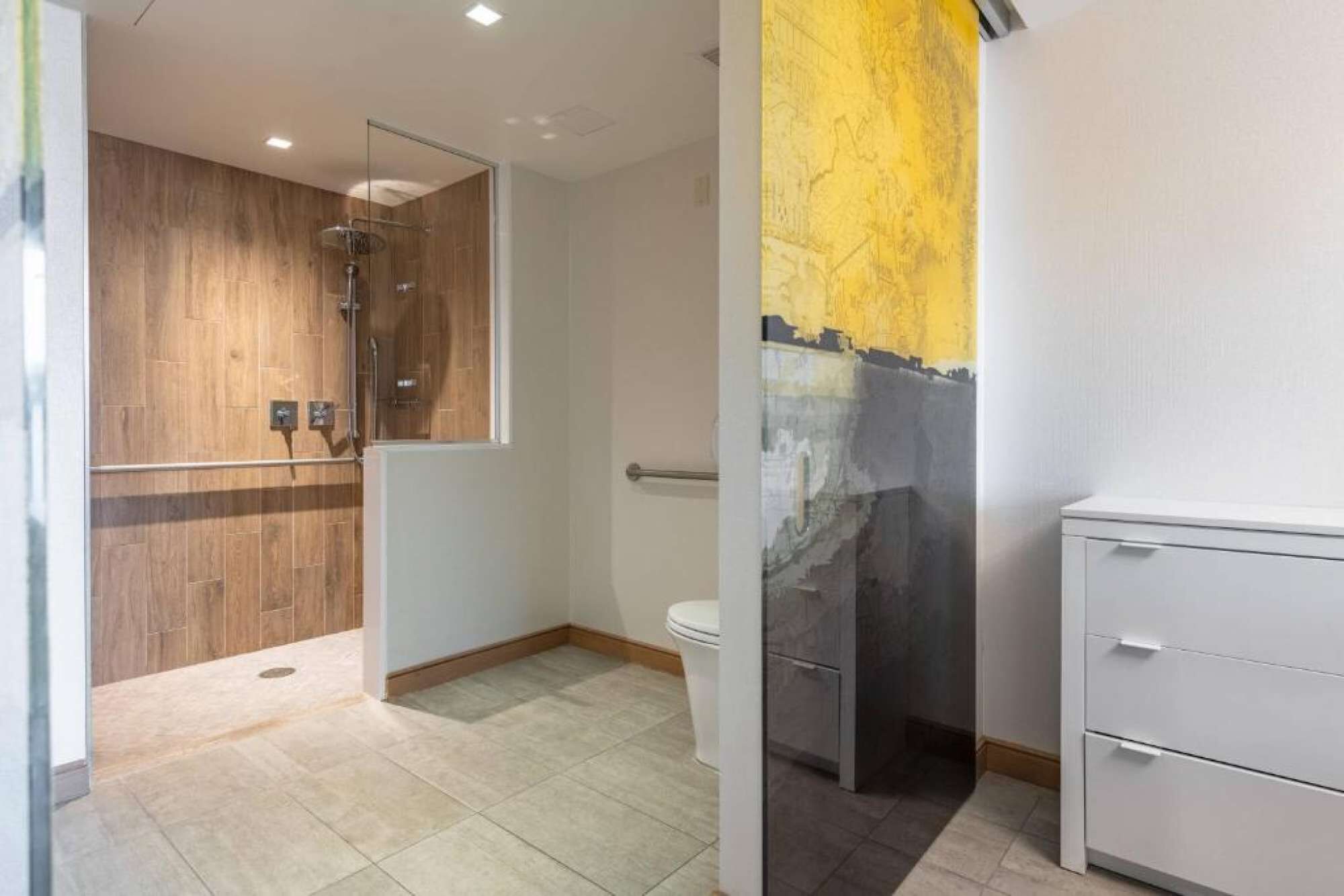 Un baño moderno con cabina de ducha de madera, inodoro y un mueble blanco.
