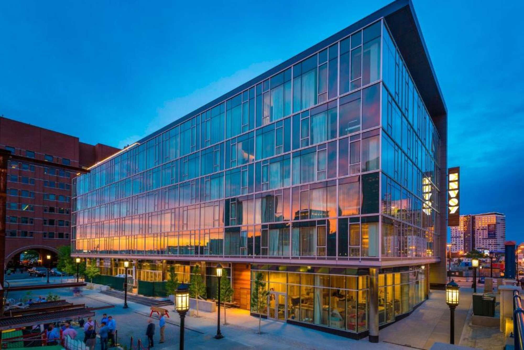 Un bâtiment moderne en verre, doté d’un toit plat et d’un grand espace d’entrée.