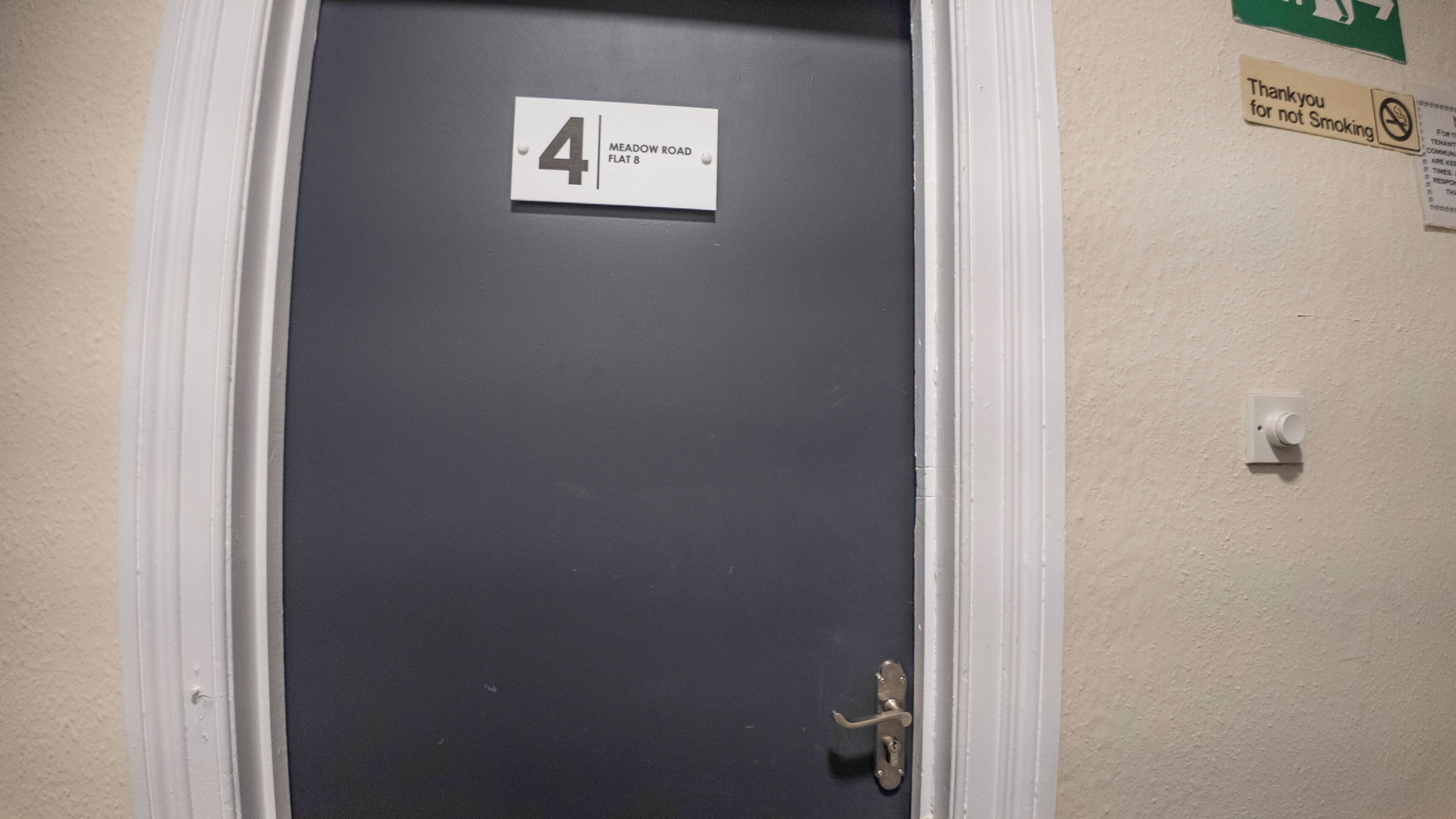 A door with a sign reading "4 MEADOW ROAD FLAT 8".