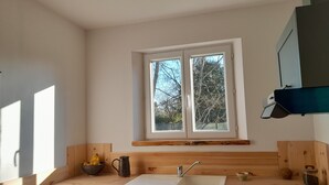 A kitchen with a window, wooden countertop, sink, and a dishwasher. - Le nouvel Érable, country house a haven of peace and greenery (Chamant)