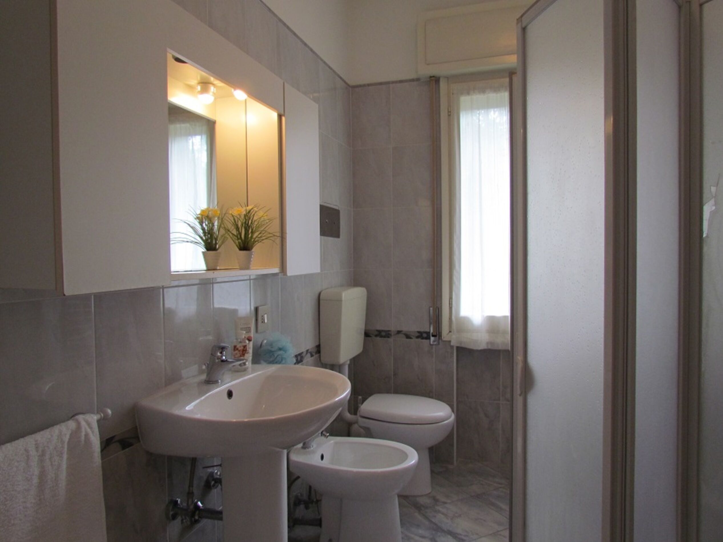 Ein Badezimmer mit Waschbecken, Toilette und einem Spiegel über dem Waschbecken.