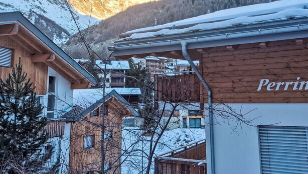 A mountain village with wooden buildings and a view of snow-covered mountains. - Perrine by Interhome (Saas-Fee)