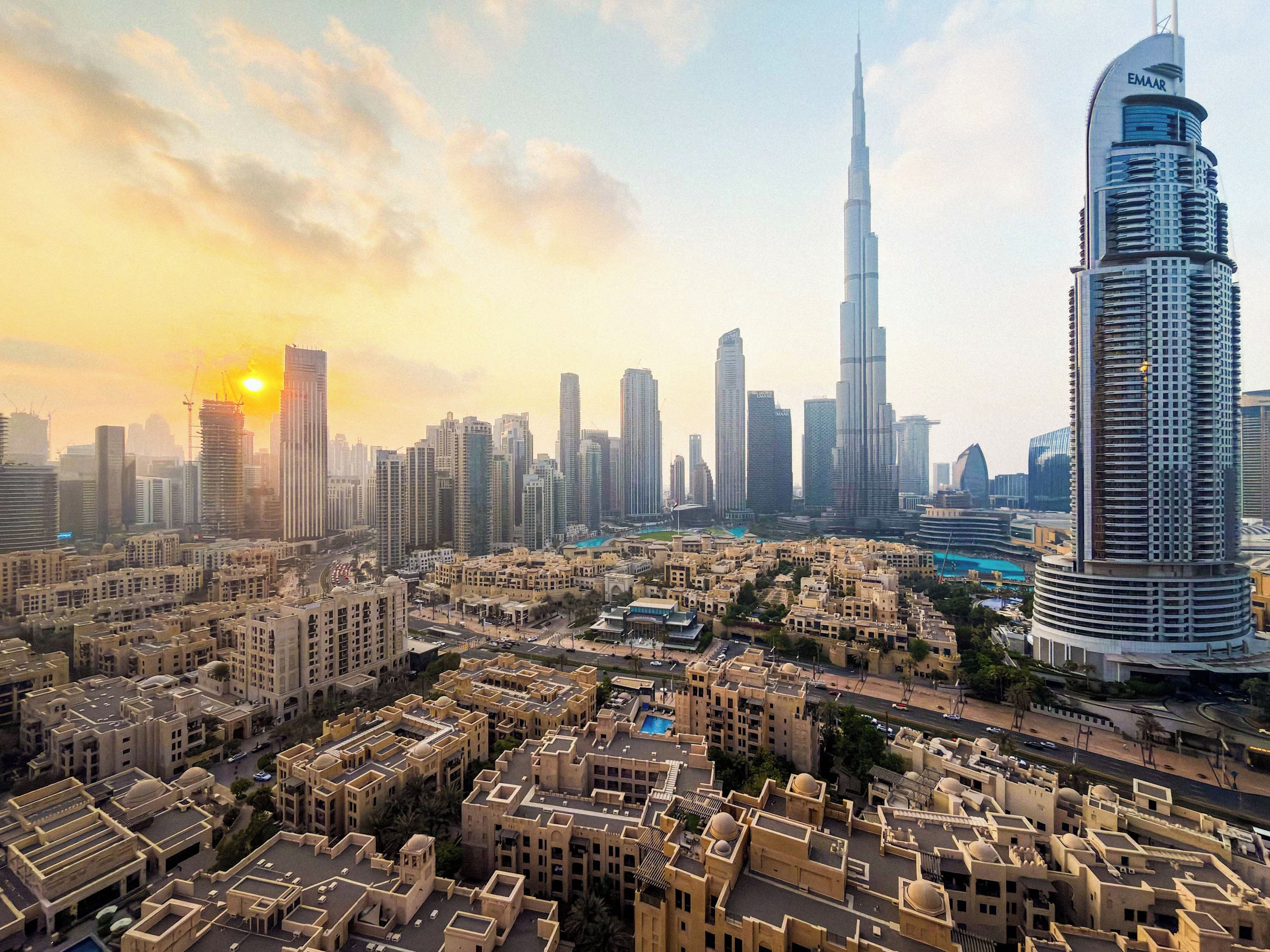 A cityscape with modern high-rise buildings, including a prominent skyscraper with a unique design.